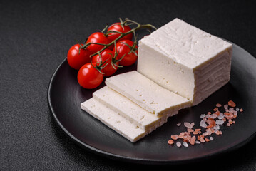 Delicious fresh ricotta cheese cut into slices with vegetables, salt and spices