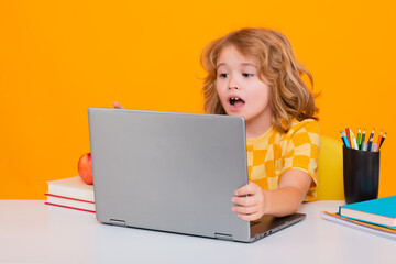 Excited school child using laptop computer. Child from elementary school with book. Little student,...