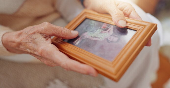 Frame, picture and hands of senior person for nostalgia, memories and thinking of past in home. Retirement home, elderly and closeup of photo to remember, mourning and depression with Alzheimers