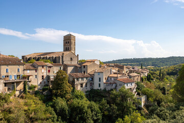 Fototapeta na wymiar A view of the village of Montolieu Aude Languedoc - Roussillon France. Trees valley ancient houses and church bell tower. 