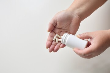 Female hands with a jar of multivitamin capsules.  Free space for text. - obrazy, fototapety, plakaty
