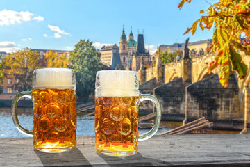 2 glasses of beer in the sunlight, in the background the view of Prague