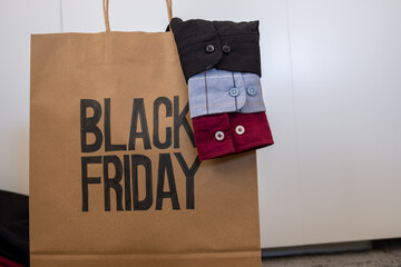 Shirt sleeve with shopping bag represents clothes sales for black friday and white friday with mock...