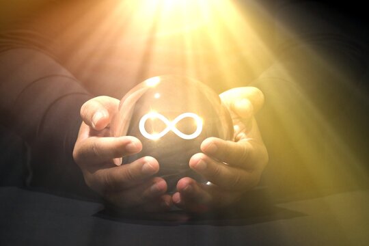 Infinity Mind Power Glass ball fortune teller, abundance , Lucky manifestation concepts. Hand holding virtual reality Infinity symbol. unlimited and infinity power business Lucky fortune telling.	