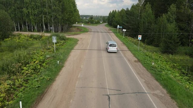 Fork in the rural road among trees in the summer