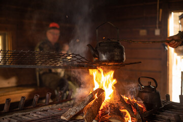 Hunters making coffe with the fire of a bonfire in a wooden windshelter in nature.jpg