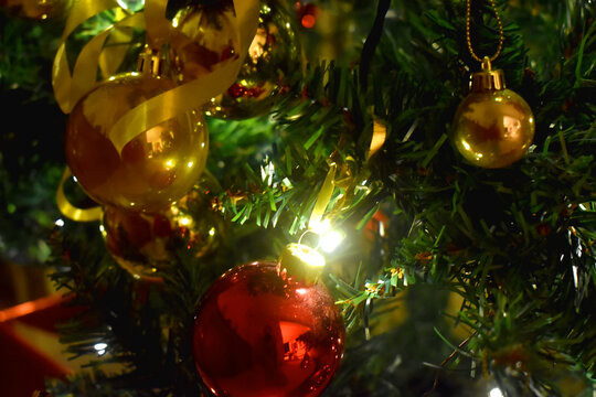 christmas trThe Christmas is decorated with red balls, golden balls, and ribbons hanging on The Christmas tree background.ee decorations