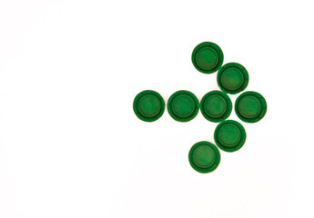 pile of plastic bottle caps in the shape of an indicative arrow with copy space on white background concept recycle agenda 2030