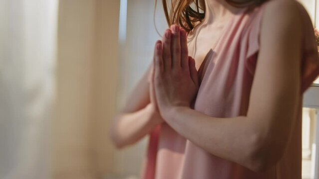 Closeup namaste hands doing yoga in morning. Peaceful woman practicing asana