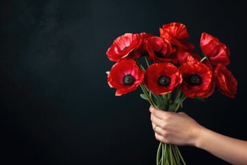 Banner with hand holding red poppy flower, symbol for remembrance, memorial, anzac day - obrazy, fototapety, plakaty