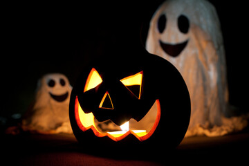 Happy Halloween. Festive decorations, cute ghosts and glow in dark Jack-O-Lantern. carved pumpkin...