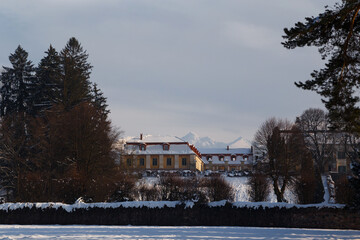 Beautiful winter photo of snow-covered Brukenthal Palace and Park in Avrig with Carpathian mountains in background, Romania