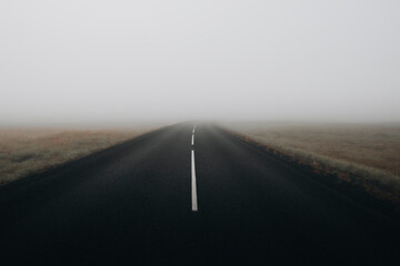 Route de bitume dans la brume en islande