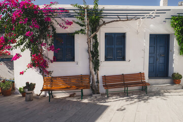 Maison dans un village grecque avec bancs et végétations 