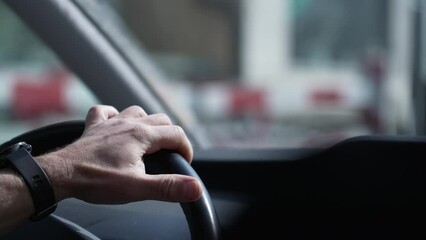 Focused Drive, Close-Up of Hand Gripping Vehicle Steering Wheel on Road