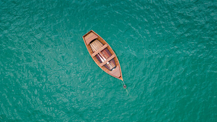 Beautiful turquoise ocean water with wooden boat on the water. Top view aerial photo.
