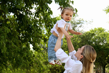 Obraz premium Mother with her daughter spending time together in park. Space for text