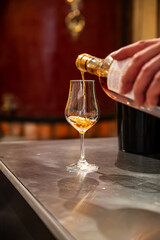 Tasting of cognac spirit aged in old French oak barrels in cellar in distillery in Cognac white wine region, Charente, Segonzac, Grand Champagne, France