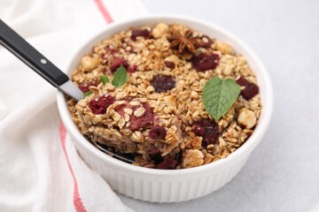 Tasty baked oatmeal with berries and nuts on light table, closeup