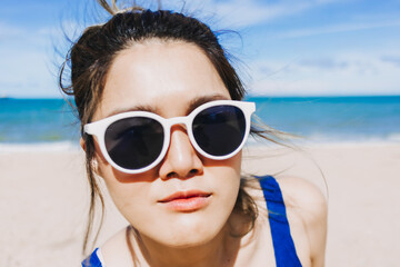 Close up face of happy asian woman in bright sunny beach in concept of skincare.