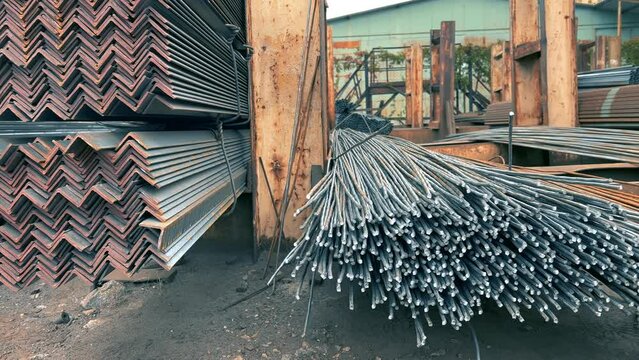 Iron rebars or a metal bars lie in an outside storage of a rolling mill