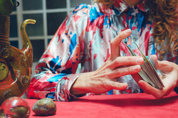 Close-up front view of female hands shuffling tarot cards