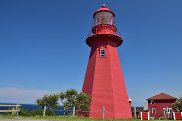 Red lighthouse La Martre, Quebec, Canada. Nice little lighthouse on top of a cape on a sunny day.