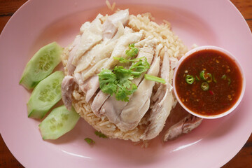 Rice steamed with chicken soup (hainanese chicken rice) with cucumber, liver and sauce for sale at Thai street food market or restaurant.