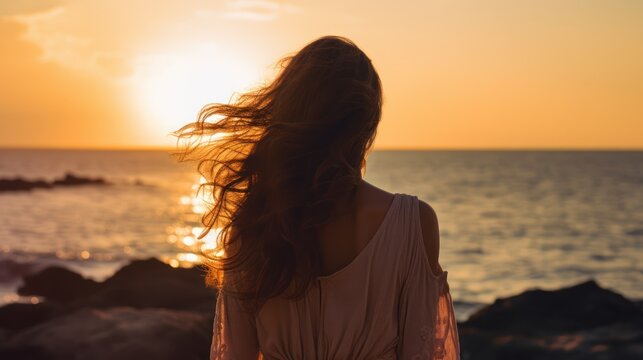 Hopeful woman, lost in the serenity of a seaside sunset