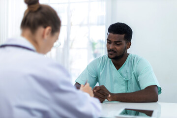 Obraz premium Physician examining male patient in hospital room. Man Patient talking to Doctor at hospital. .