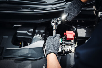 Close-up hand auto mechanic using the wrench to repairing car engine problem. Concepts of check and...