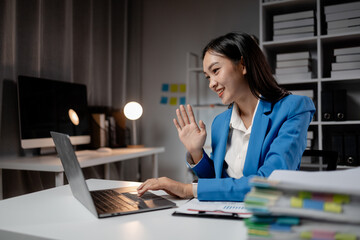 Asian woman is in office of a startup company, young businesswoman is giving a presentation via online video call to group of company executives, presenting a management budget. Online meeting ideas.