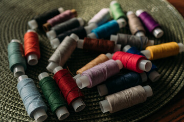 multicolored spools of thread are scattered on the table. Preparation for sewing. Tailor's table....