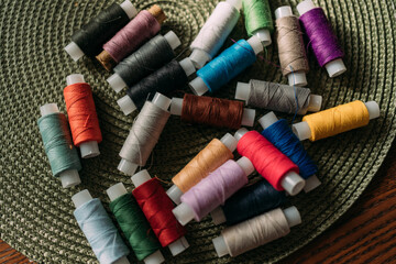 multicolored spools of thread are scattered on the table. Preparation for sewing. Tailor's table....