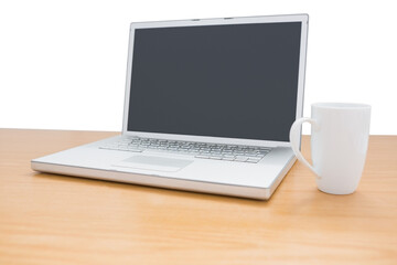 Digital png illustration of laptop and mug on wooden desk on transparent background