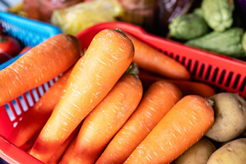 orange color Store shelves. Carrot counter. To the grocery store for lunch. Assortment in the supermarket. healthy food. Bunches of colorful orange carrots with green tops crate with carrot i