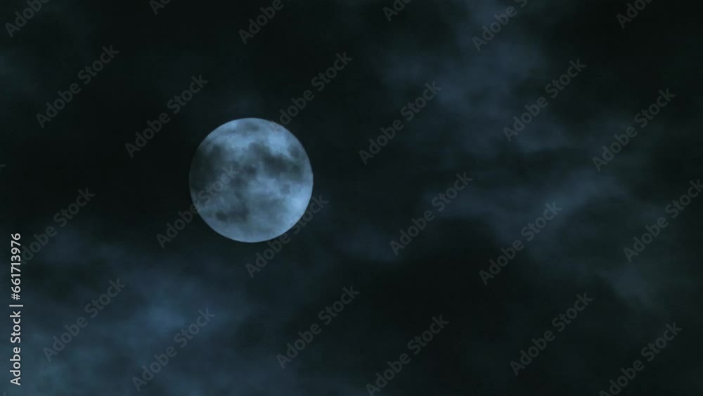 Sticker full moon in the sky with clouds at night. the moon hangs motionless while black clouds fly past it.
