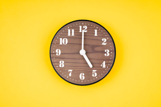 Retro wooden clock at 5 O' clock.