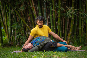 Naklejka na ściany i meble Thai massage therapy session, outdoors with bamboo background