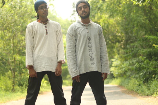 Two Indian Boys wearing Khadi Kurta and a Bandana or neck gaiter standing on the road with green trees and vegetation in the background, Standing staright