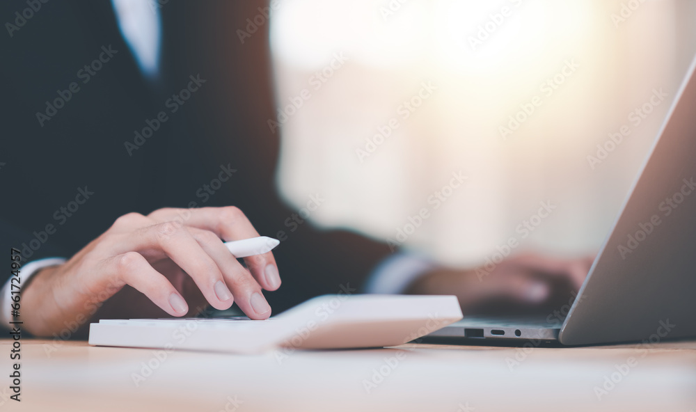 Poster Businessman using a calculator to calculate numbers ,profit and loss statement review of company performance ,cost analysis ,financial paperwork ,Calculation of tax information reports