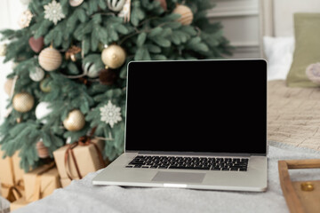 Laptop with gifts, Christmas tree in the background