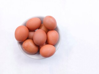 eggs in a basket. a pile of chicken eggs in a white bowl isolated on a white background. eggs with brown shells. healthy food
