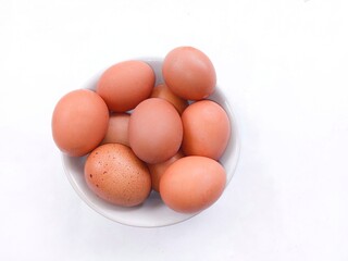 eggs in a basket. a pile of chicken eggs in a white bowl isolated on a white background. eggs with brown shells. healthy food
