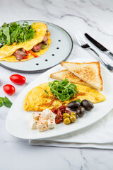 Breakfast of eggs with meat, herbs and drops of sauce with bread in a round plate top view