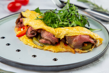 Breakfast of eggs with meat, herbs and drops of sauce in a round plate side view