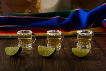 Tequila shots with salt and lime on a bar table. Shots of tequila and typical mexican elements.
