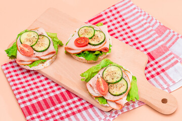 Light Breakfast. Quick and Healthy Sandwiches. Rice Cake with Ham, Tomato, Fresh Cucumber and Green Salad on Wooden Cutting Board