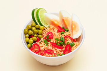 Beautiful Noodle Dish with Green Pea, Eggs, Red Hot Pepper, Greens and Lime on White Background. Instant Noodles
