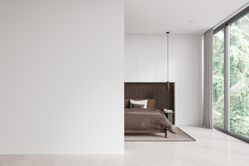 White bedroom interior with empty wall